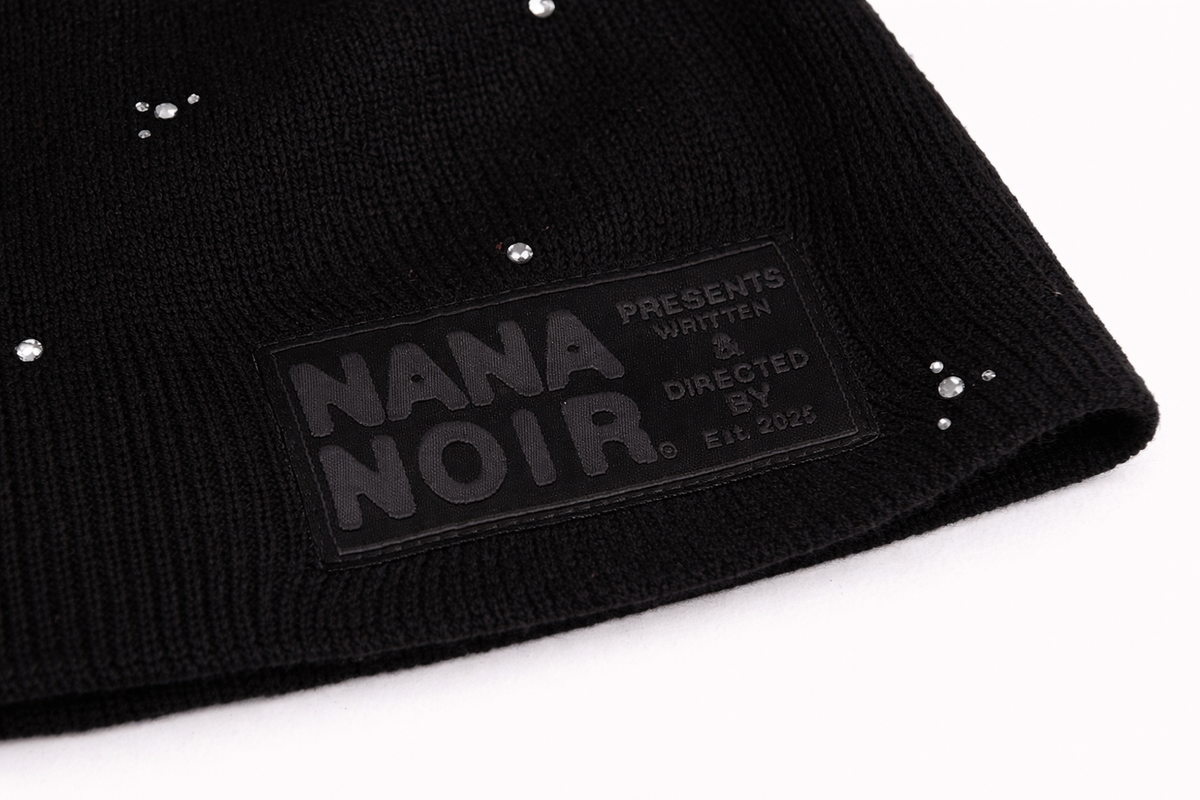 Close-up of BACK HOME black ribbed beanie with silver studs and tonal Nana Noir patch
