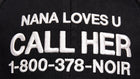 Close-up of white CALL HER slogan embroidery on black cotton cap