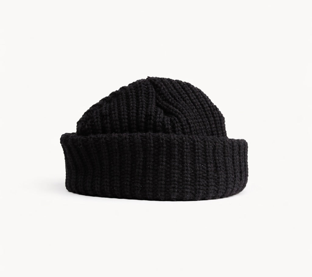 Rear view of CHECK IN black crochet beanie showing the wide folded cuff